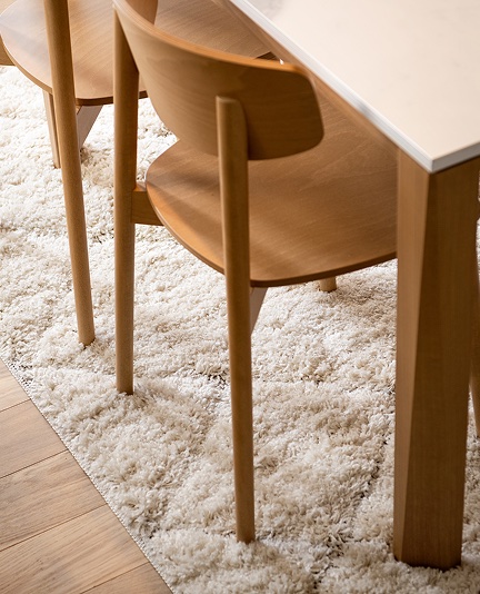 Timber dining chairs tucked under a pale dining table